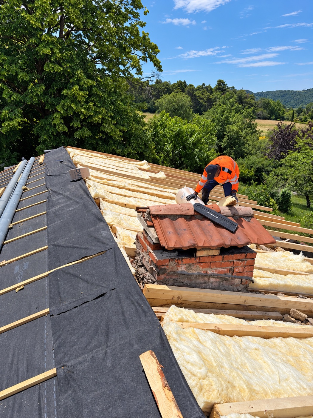 Isolation thermique posée entre les chevrons d’une toiture, avec intervention sur le chantier